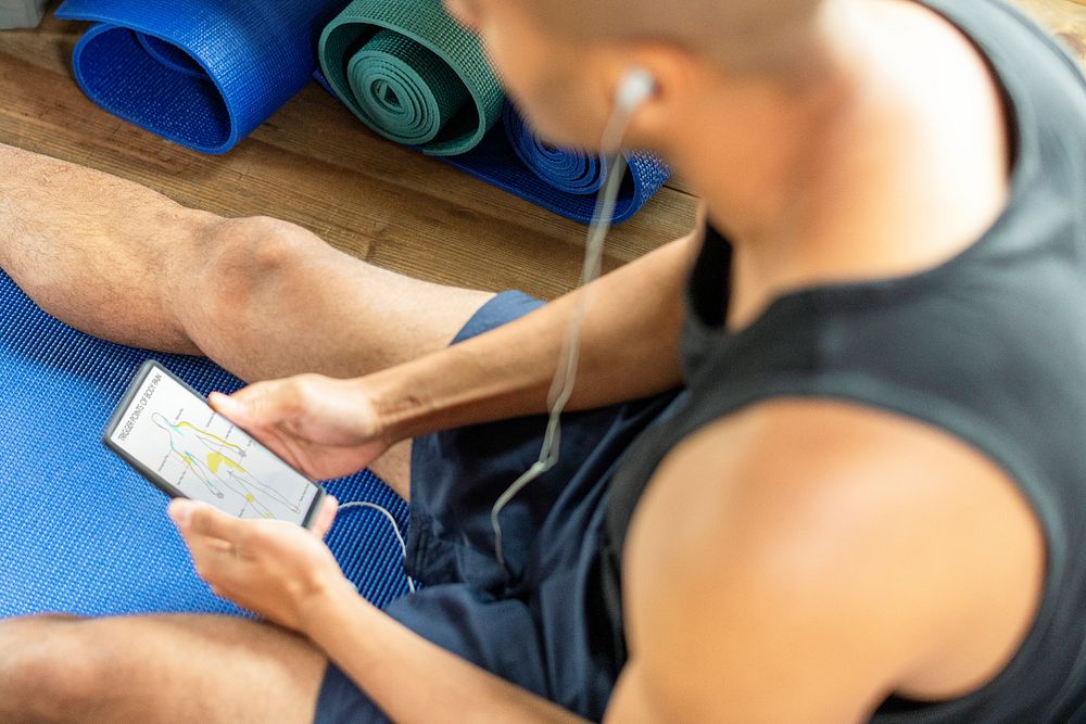 Healthy man listening to music at a gym