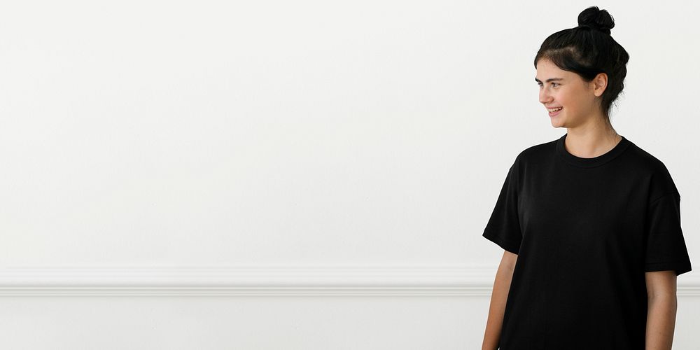 Portrait of a cheerful girl in a black tee over a white background