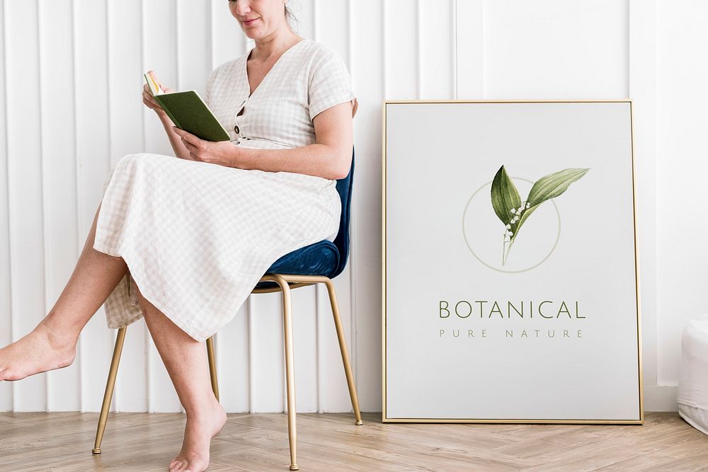 Woman reading a book sitting by a botanical frame mockup
