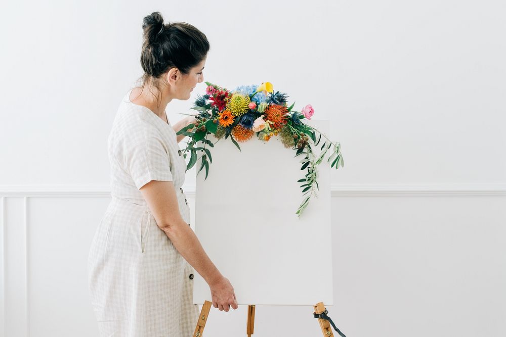 Florist decorating a sign with flowers