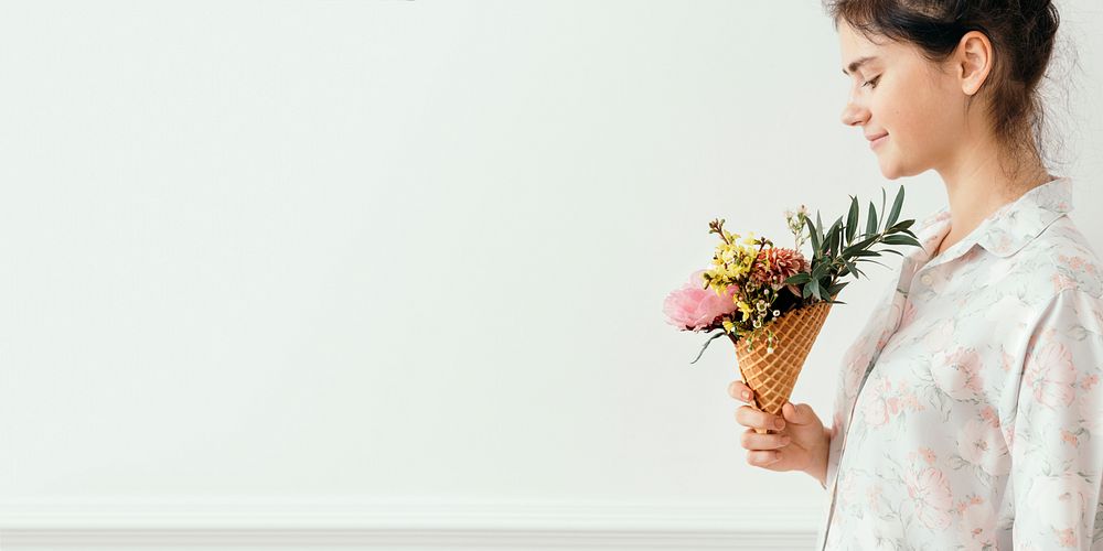 Beautiful young girl with flowers in an ice cream cone