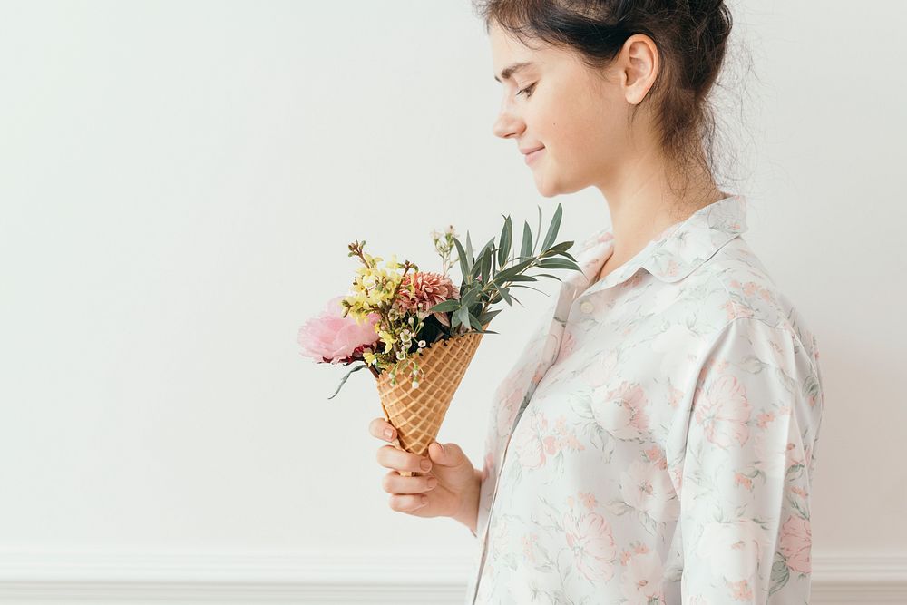 Beautiful young girl with flowers in an ice cream cone