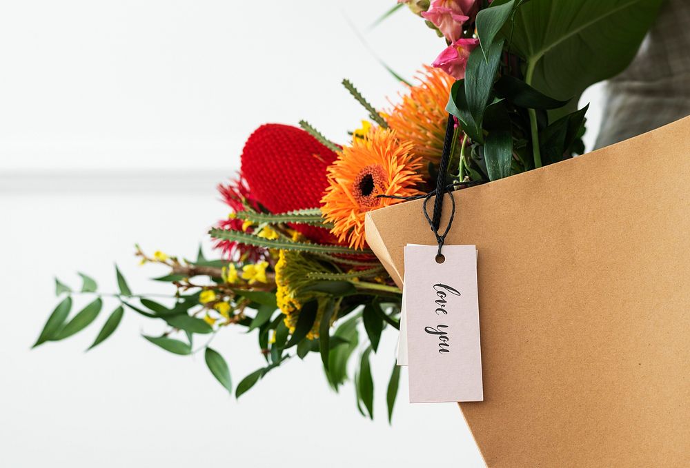 Fresh colorful flowers in a brown bag with a card mockup