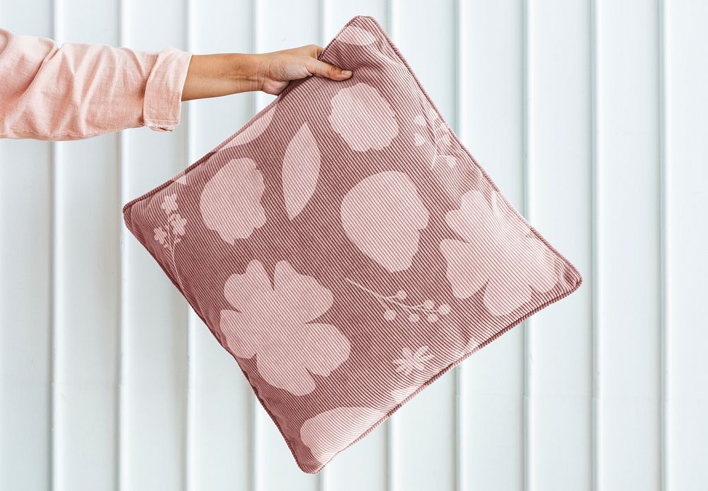 Woman holding pink foliage patterned cushion