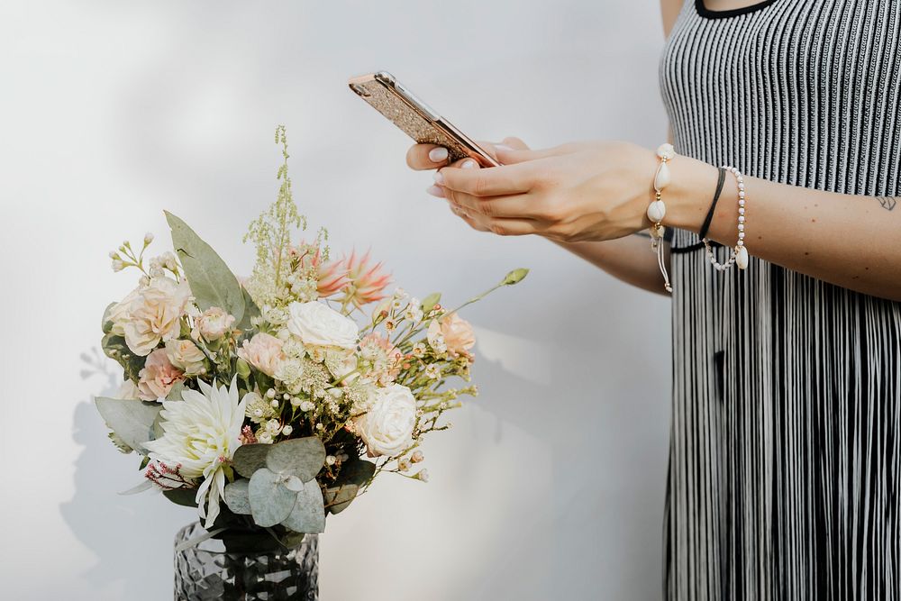 Woman taking a photo of flowers with a phone
