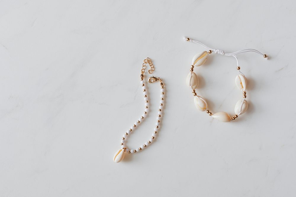 Seashell jewelries on white marble background