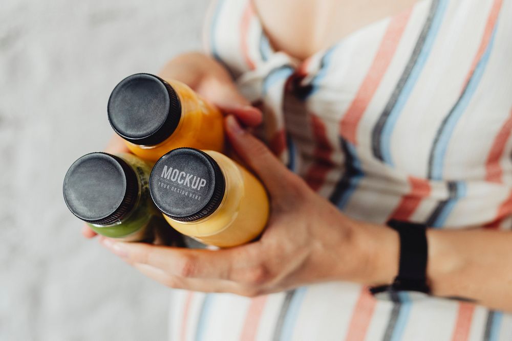 Expecting mother holding 3 bottles of homemade cold-press vegetable and fruit juice mockup