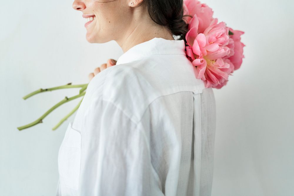 Happy woman with a bouquet of coral sunset peony