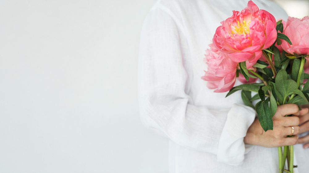 Woman holding a bouquet of peonies