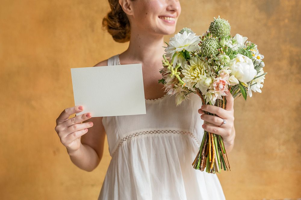 Happy woman holding a blank card with a bouquet of flowers