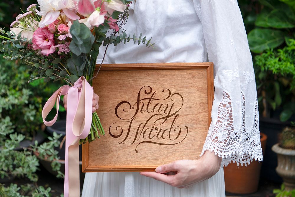 Woman holding a bouquet of flowers with a wooden board