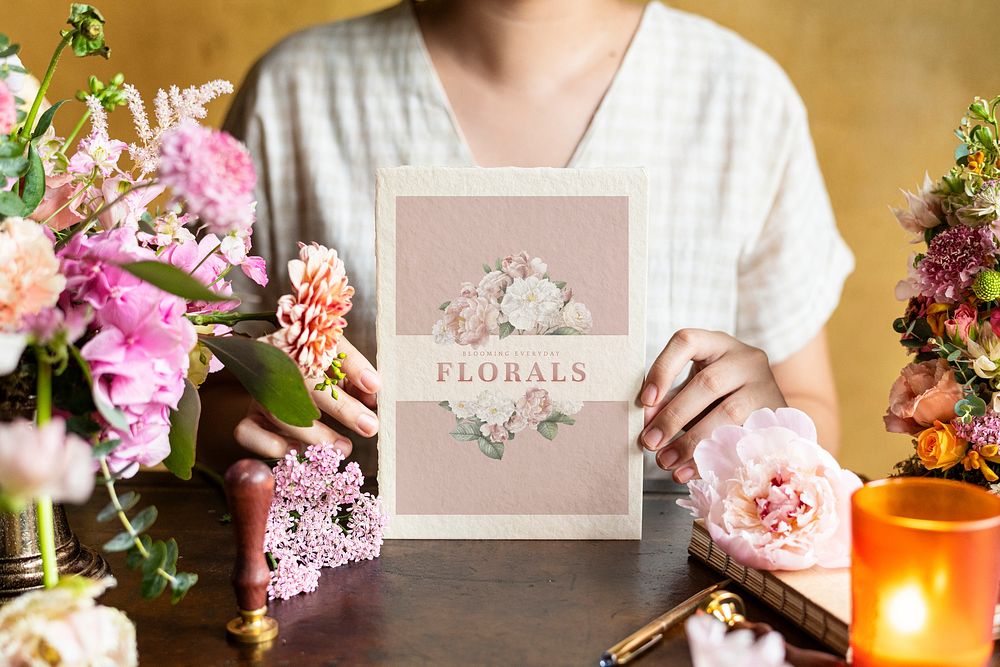 Woman holding a card mockup surrounded by flowers