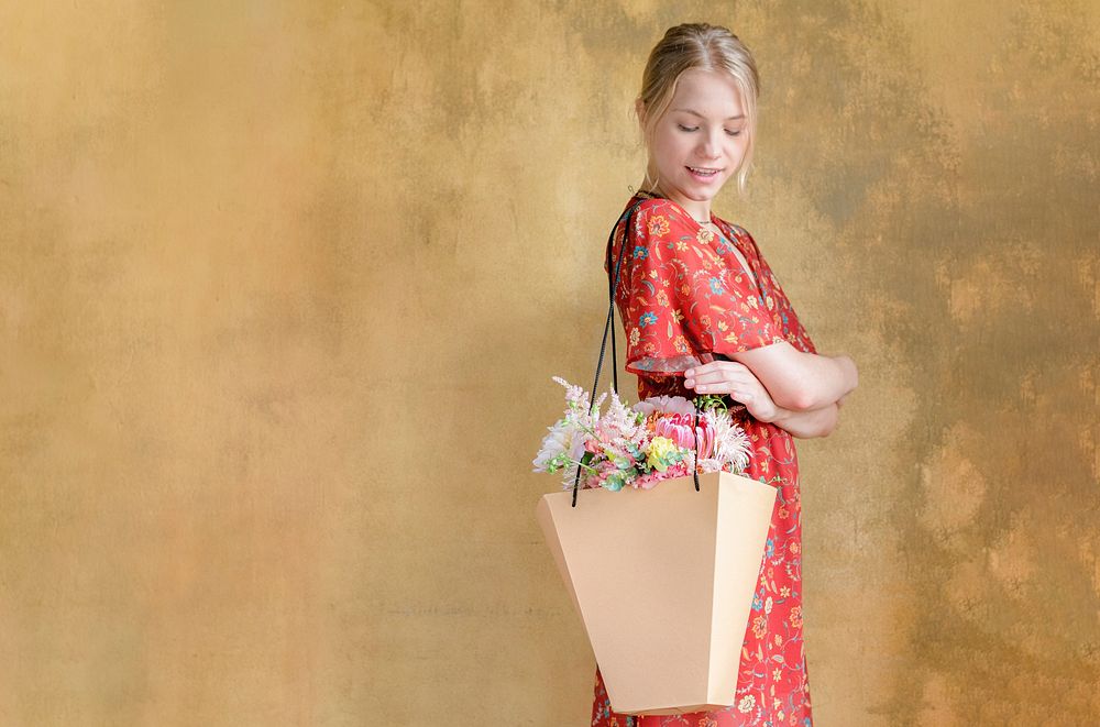 Woman carrying a bouquet of flowers in a paper bag