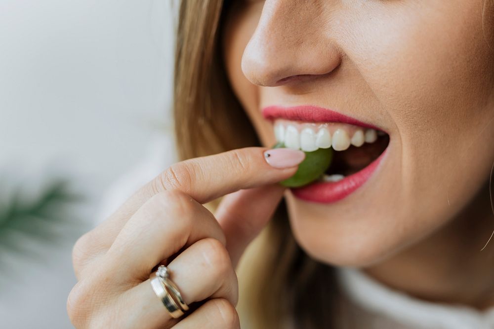 Woman eating a green grape