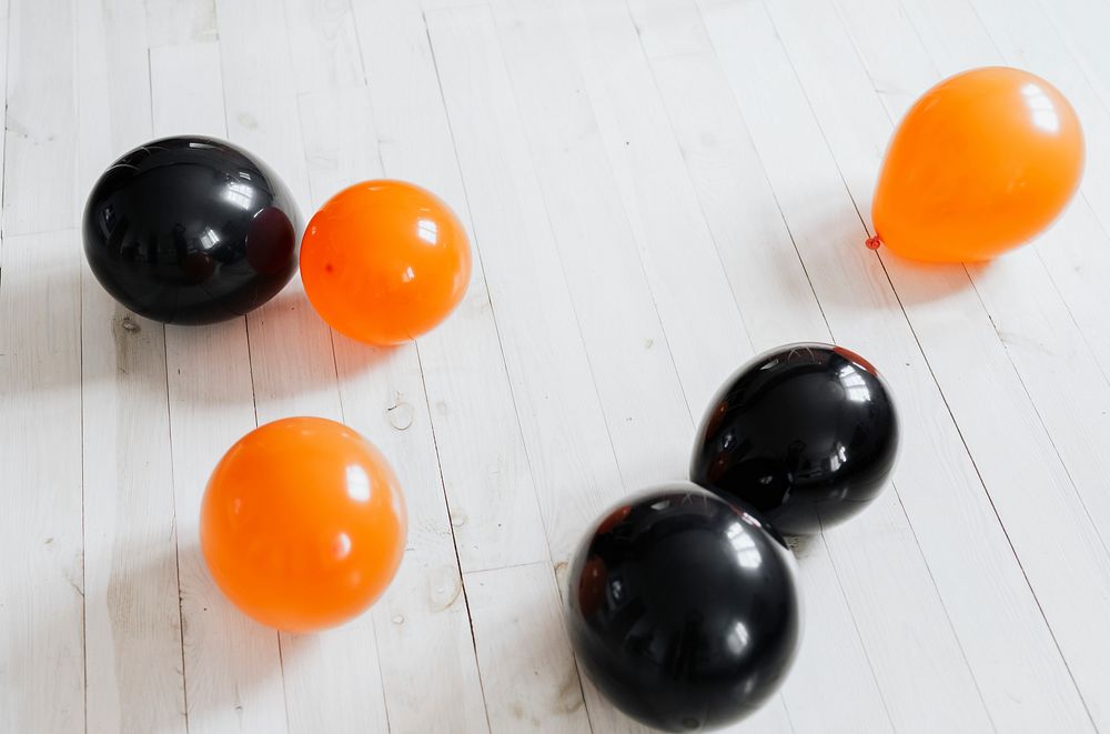 Orange and black balloons on the white wooden floor