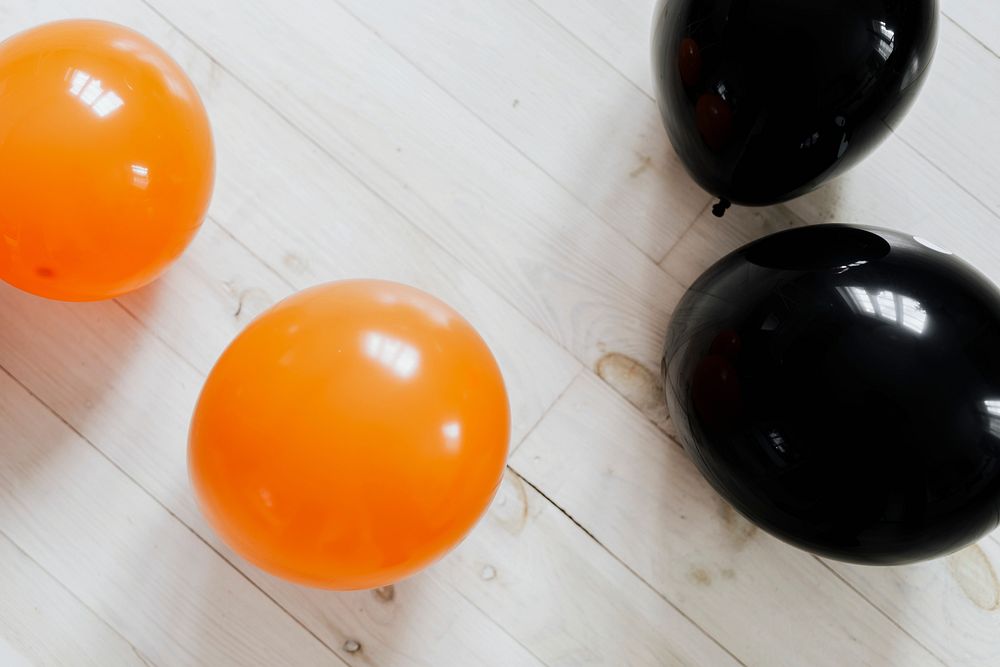 Orange and black balloons on the white wooden floor