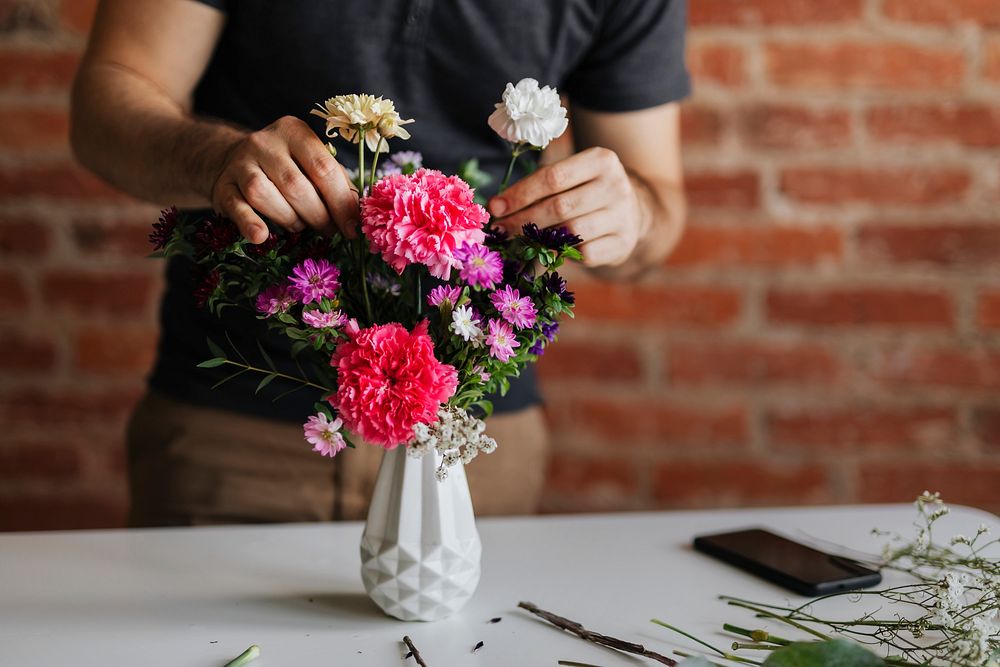 Man arranging flowers in a vase