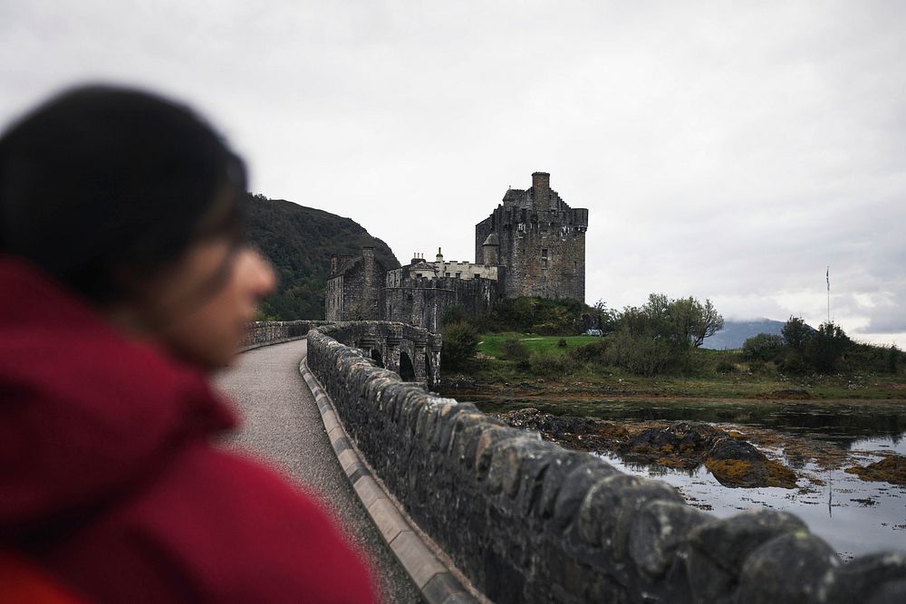 Female traveler on a bridge at Eilean Donan Castle, Scotland