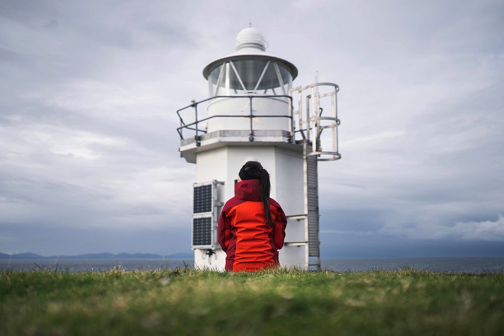 Female traveler at Vaternish Lighthouse on Isle of Skye, Scotland