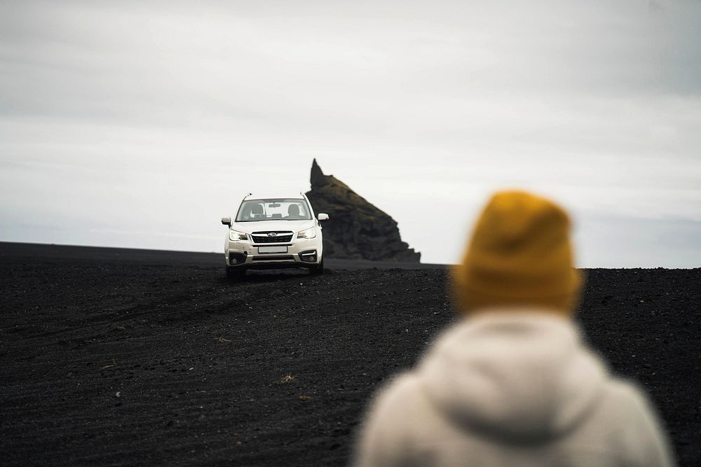 Car driving on black sand beach in Iceland
