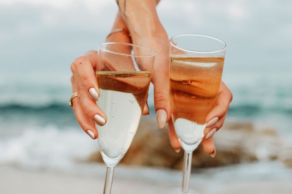Women with glasses of champagne at the beach