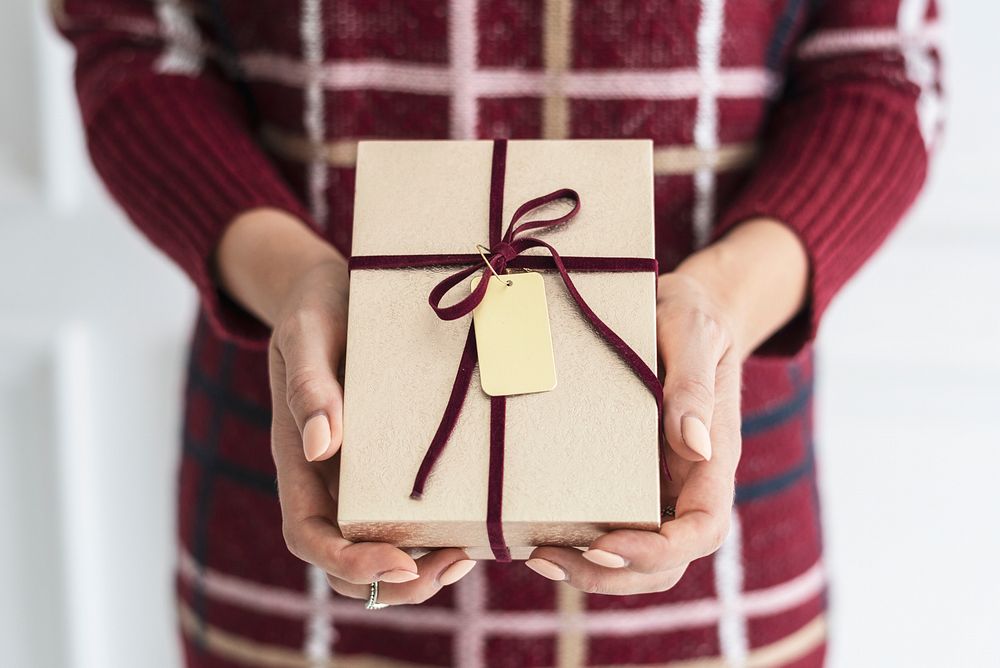 Woman holding a gold present with a card