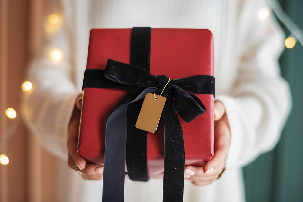 Woman holding a red present with a card