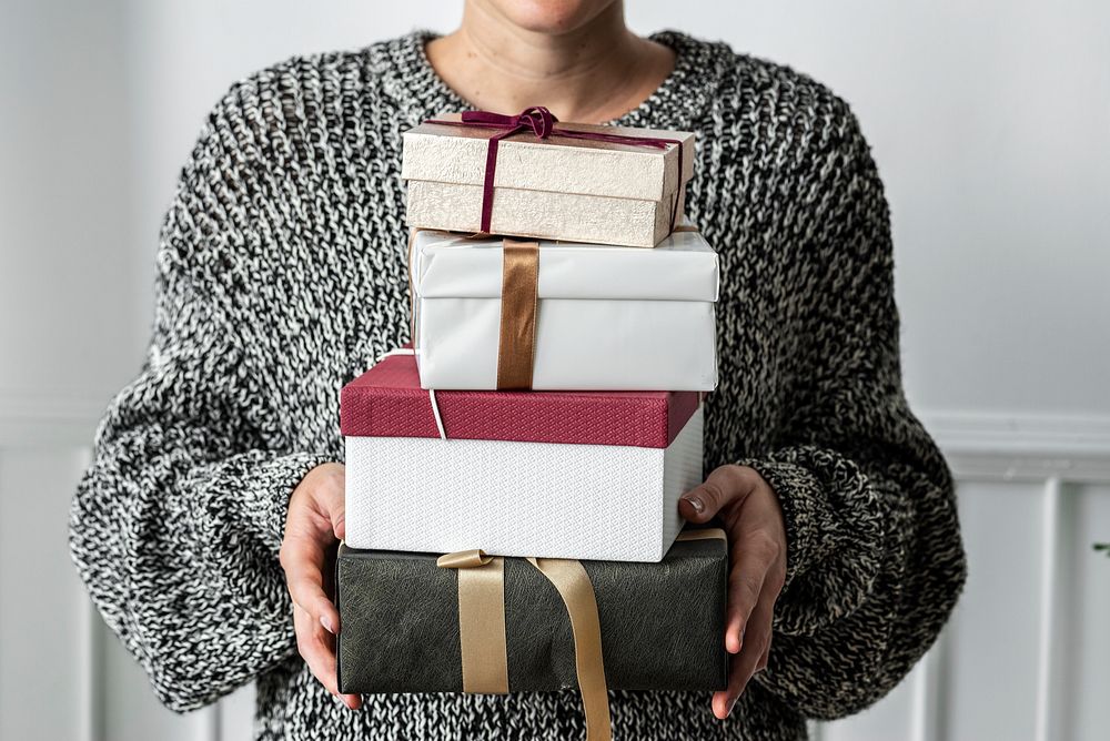 Woman carrying a stack of presents