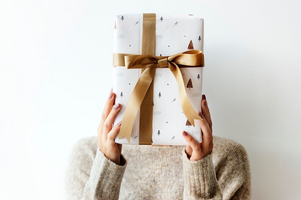 Woman covering her face with a white present