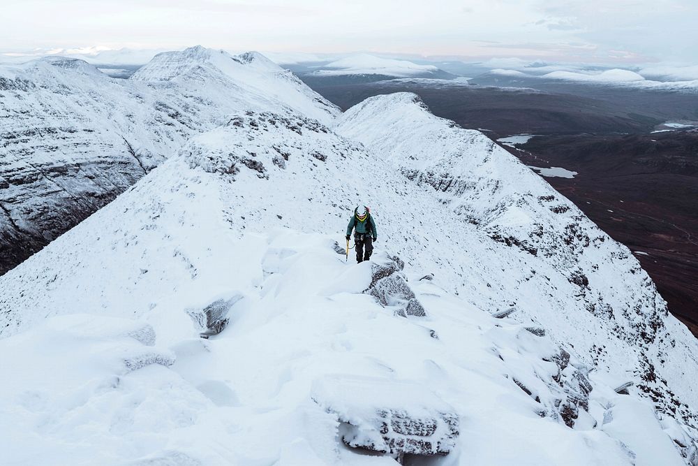 Mountaineer climbing in the snow at Liathach Ridge, Scotland