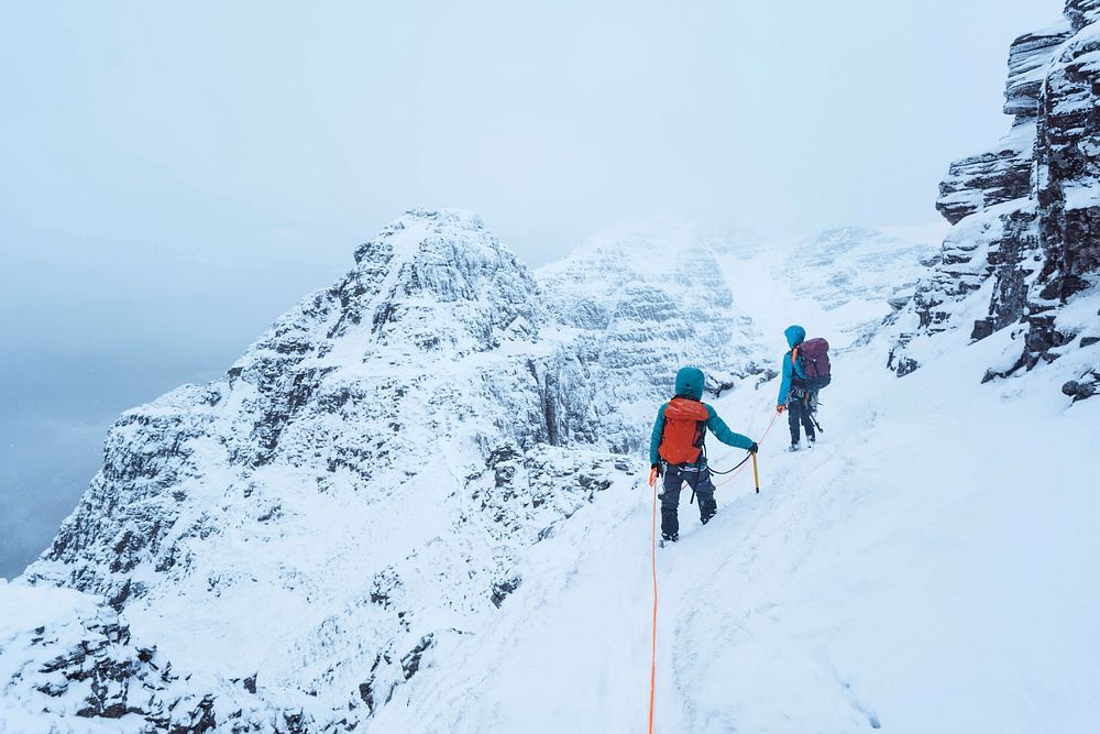 Mountaineers climbing a snowy Liathach Ridge in Scotland