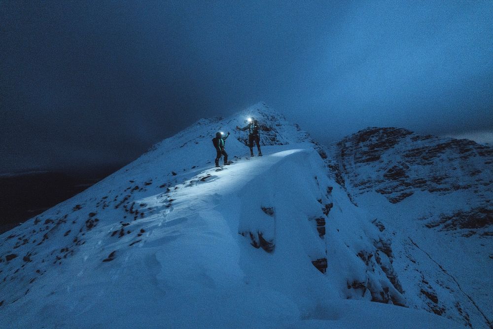 Mountaineers trekking in the cold night at Liathach Ridge, Scotland