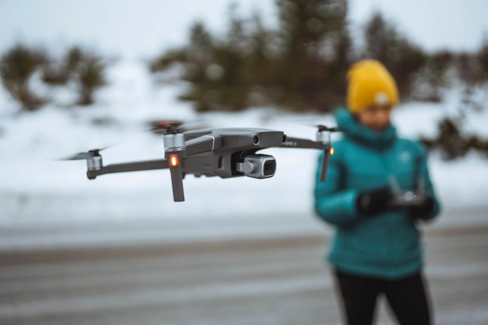 Woman flying a drone in Lofoten, Norway