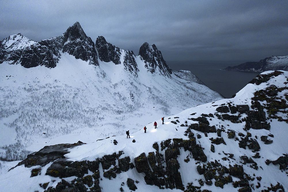 Hikers walking up Segla mountain during the blue hour