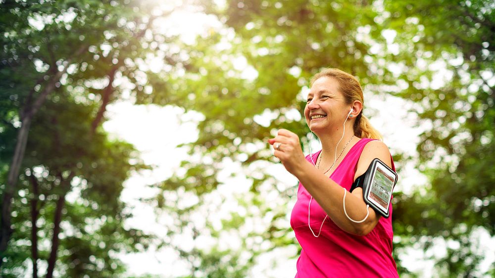 Cheerful lady jogging while listening to music