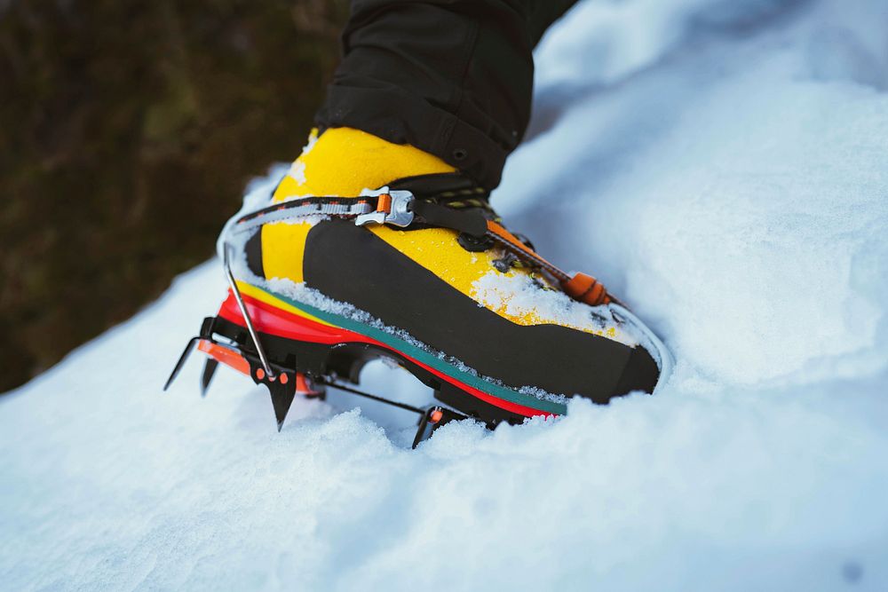 Man climbing a snowy mountain with crampons