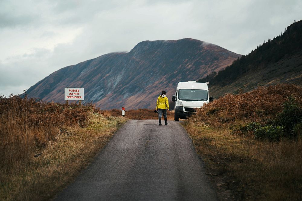 Woman walking back to her van in the Highlands of Scotland