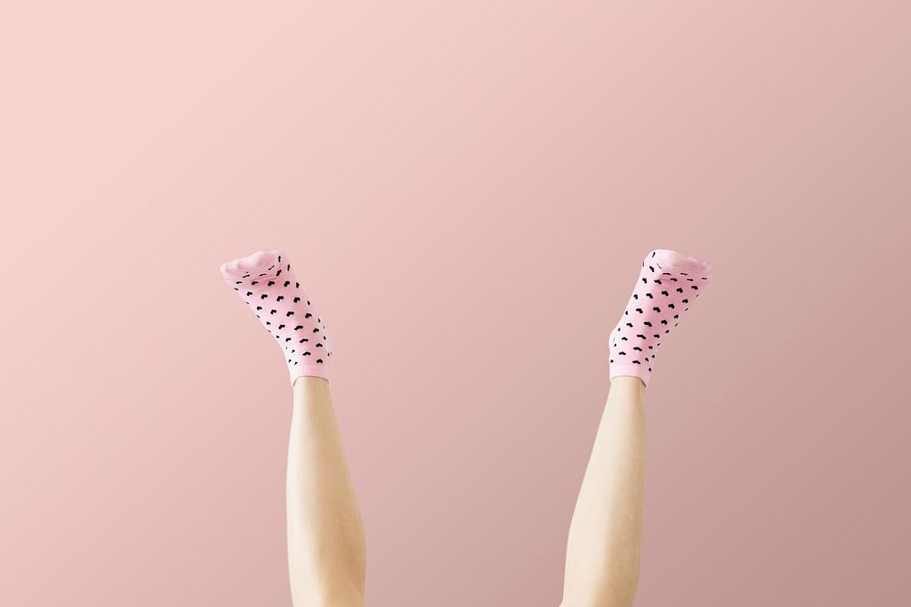 Woman wearing pink socks against a pink background 
