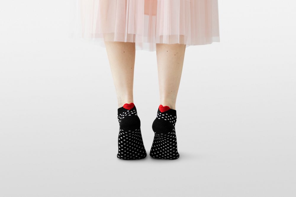 Woman wearing black socks with a red hearts 