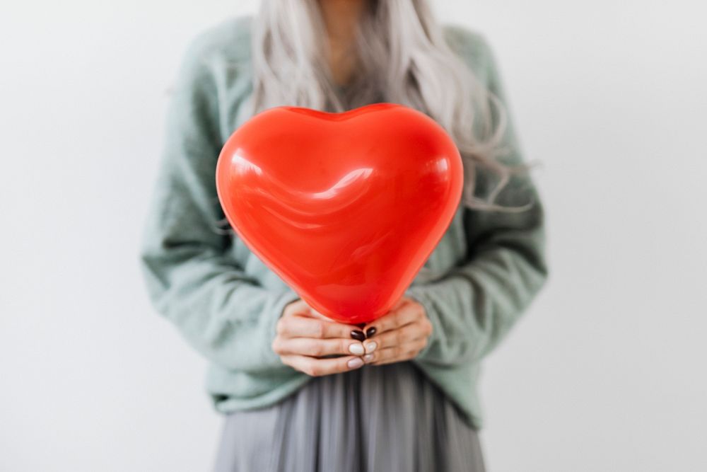 Woman showing a heart red balloon mockup