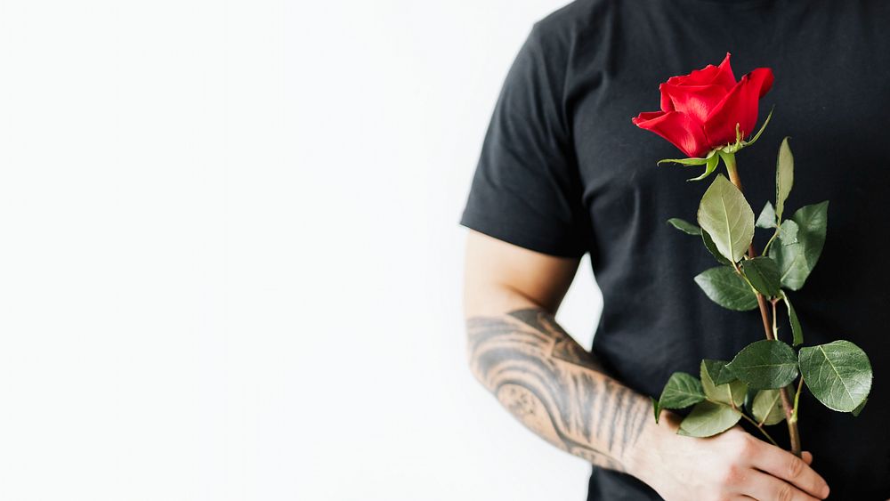 Tattooed man with a rose background