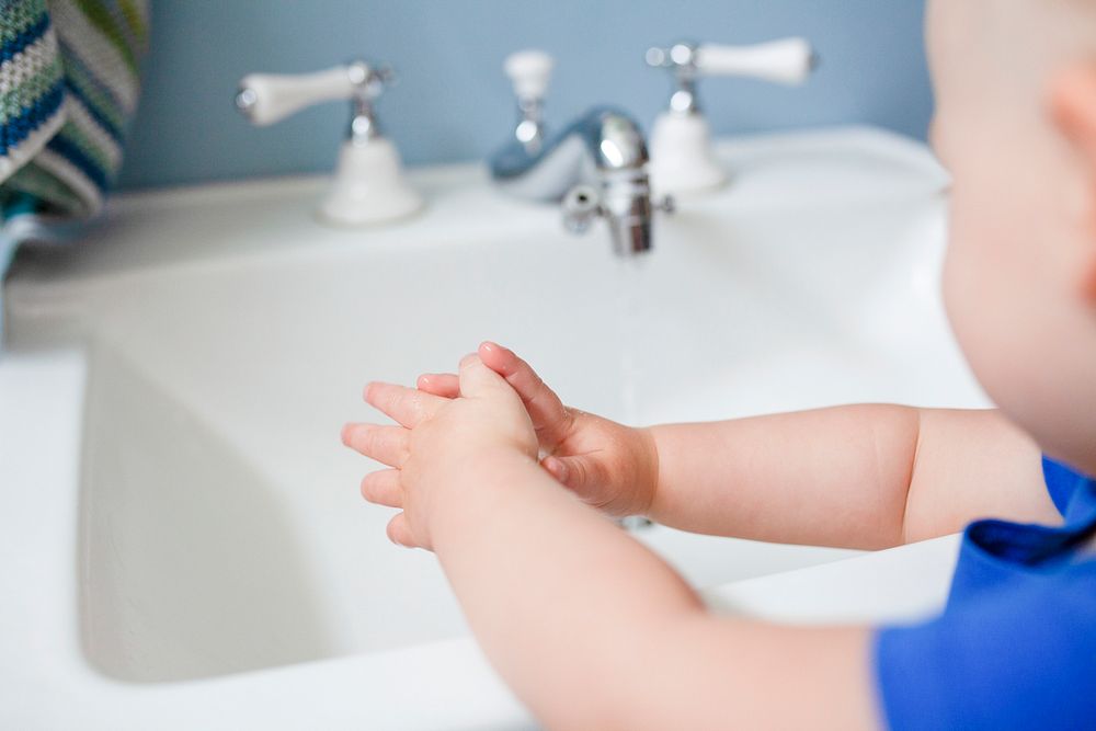 Cute little girl learning how to wash her hands in the new normal