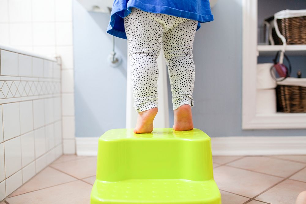 Toddler&rsquo;s bare feet tiptoeing on the stool