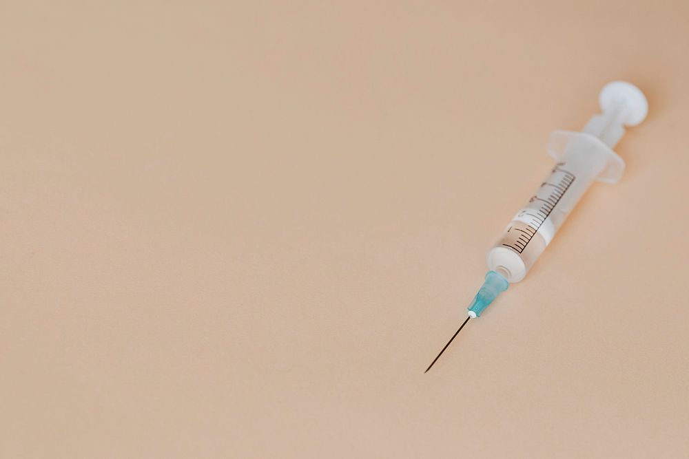 Closeup of a syringe on a brown background