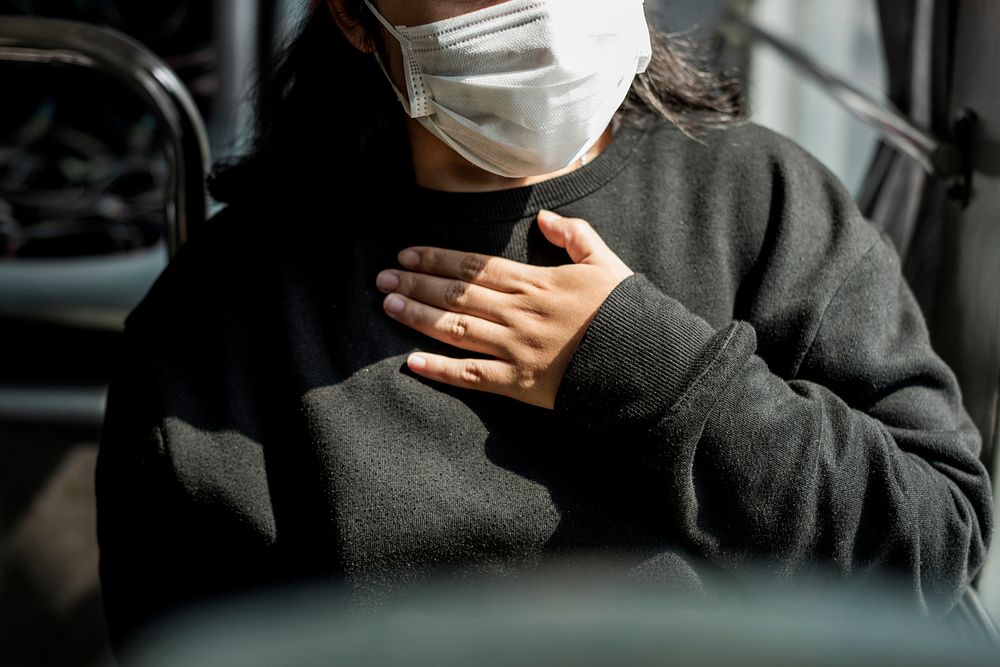 Sick woman in a mask having a difficulty breathing during coronavirus pandemic