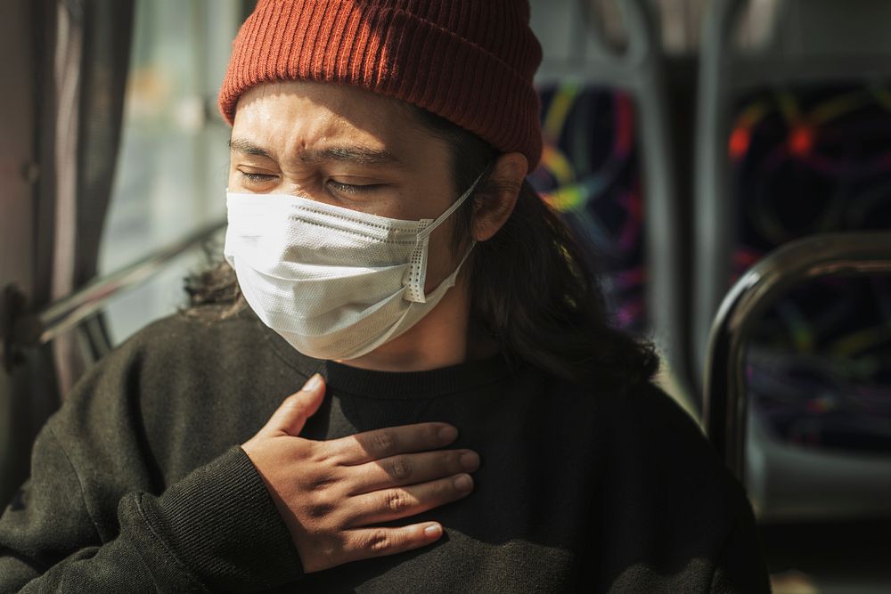 Sick woman in a mask having a difficulty breathing during coronavirus pandemic