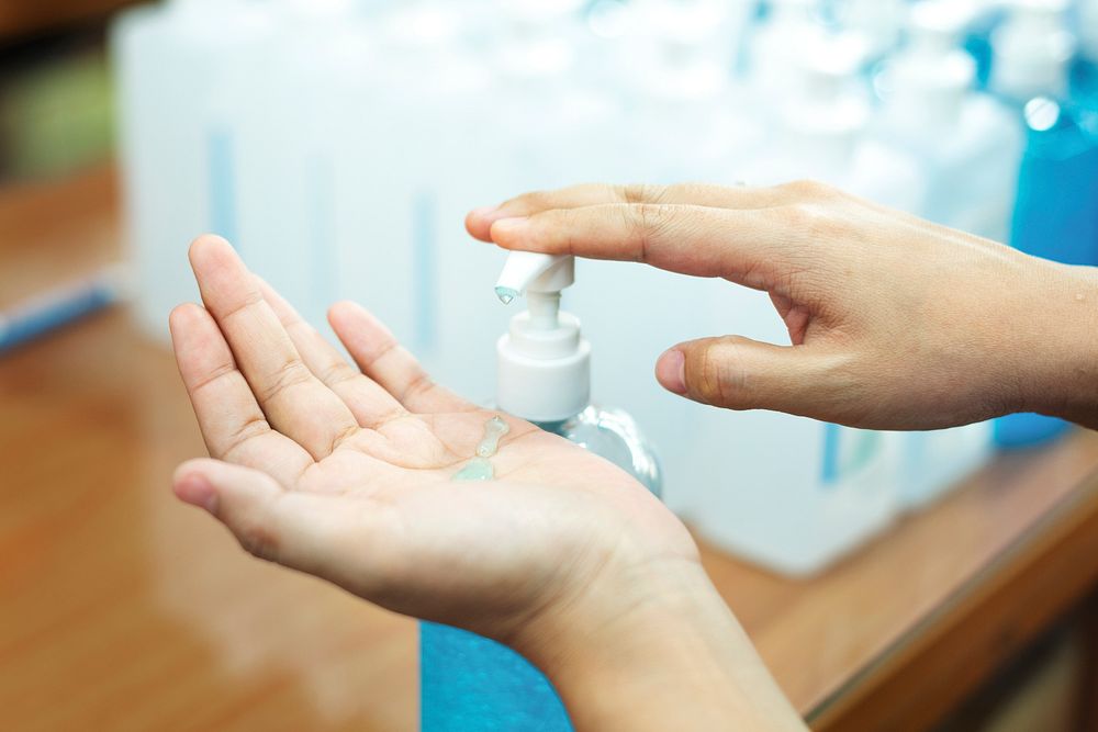 Woman cleaning hands with a hand sanitizer gel to prevent coronavirus contamination