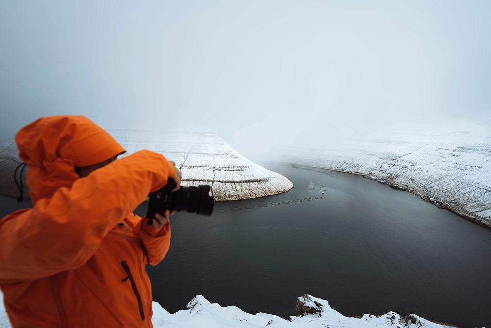 Photographer capturing view of snowy mountains in the Faroe Islands