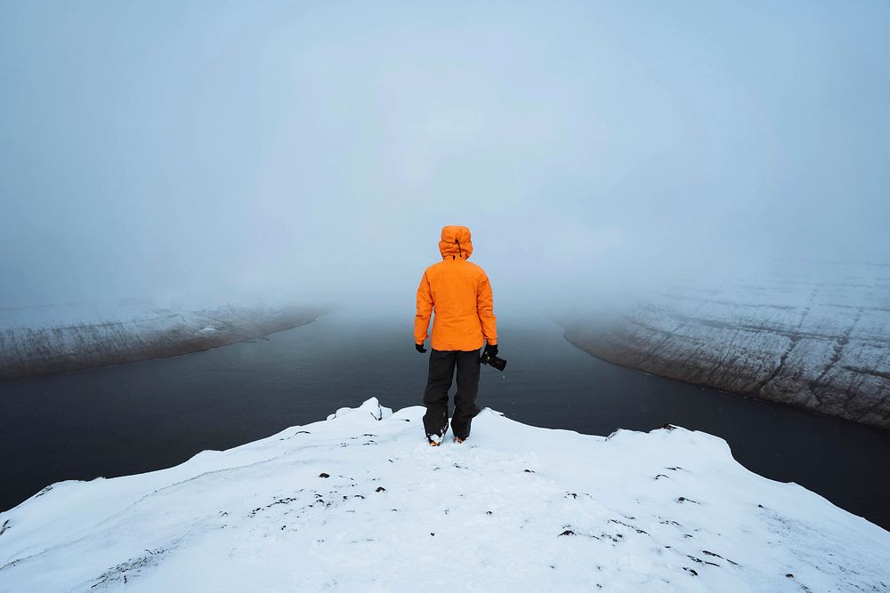 Photographer at the snowy mountain in the Faroe Islands