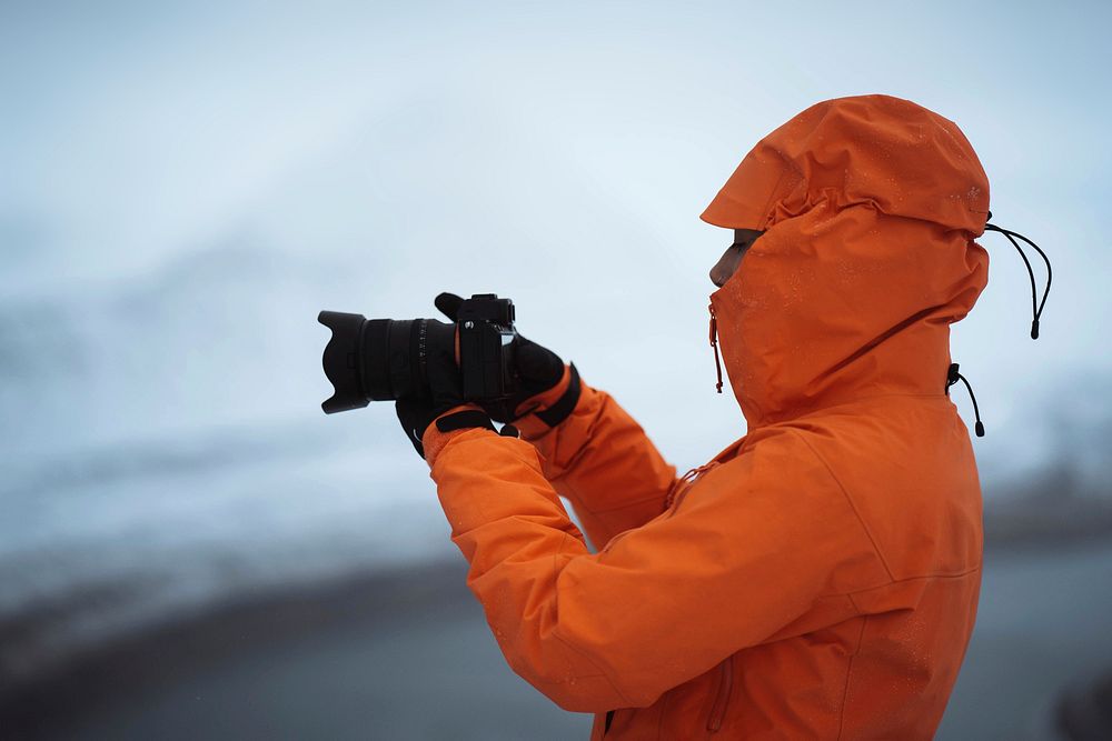 Landscape photographer at snowy Hvíthamar mountain in the Faroe Islands